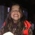 A Happy Little Girl Youth Hunter with a Big Smile, as she sits in a deer hunting blind | Hunting Magazine