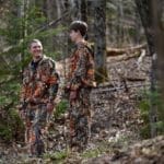 Barrie North, left, and Peter North, right, a father-son duo from Strafford, Vt., talk in the woods behind their home on Thursday while sporting their new invention.
